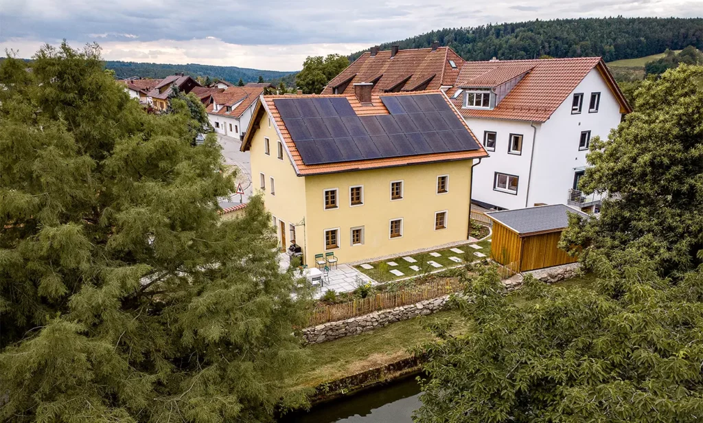 Drohnenaufnahme des Baderhauses mit Terrasse und Zufahrt